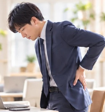 腰に手を当てるスーツ姿の男性