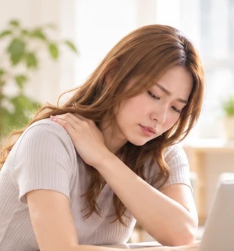 肩に手を当てて前かがみになる女性